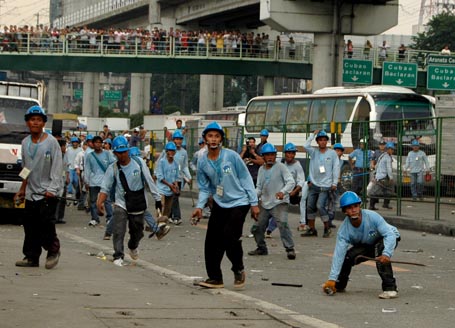 Mga miyembro ng demolition team na nang-iitsa ng bato, bote at kung anu-ano pang gamit laban sa mga residente. (KR Guda)