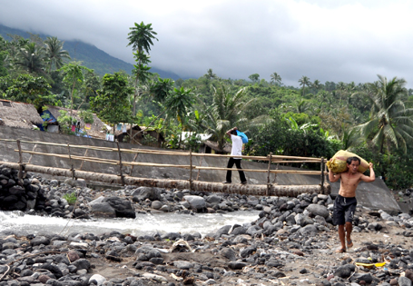 Gumawa ng lakarang tulay mula sa puno ng niyog ang mga residente ng isang barangay sa Malinao, Albay dahil matagal nang nasira ng bagyo ang sementadong tulay at kalsada patungo sa kanilang bayan. (KR Guda)