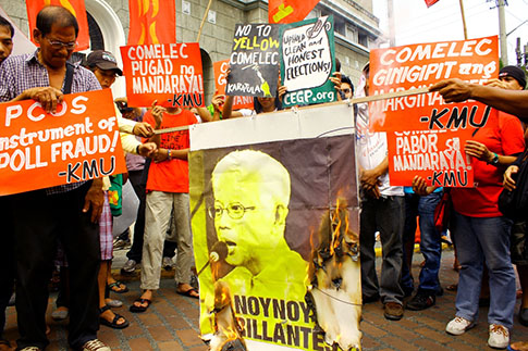Sinunog ng mga miyembro ng Kilusang Mayo Uno at Anakbayan ang imahen ng "dilaw" na Sixto Brillantes para kondenahin ang panggigipit umano ng Comelec sa mga kritiko ng administrasyong Aquino. (Kontribusyon/Karatula)