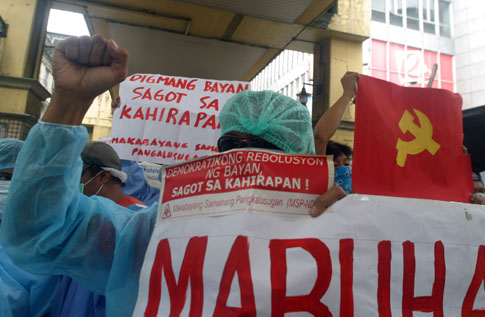 Suot ng mga nagpoprotestang rebolusyonaryo mula sa Makabayang Samahang Pangkalusugan o MSP ang operating room gown at cap mask. (Boy Bagwis)