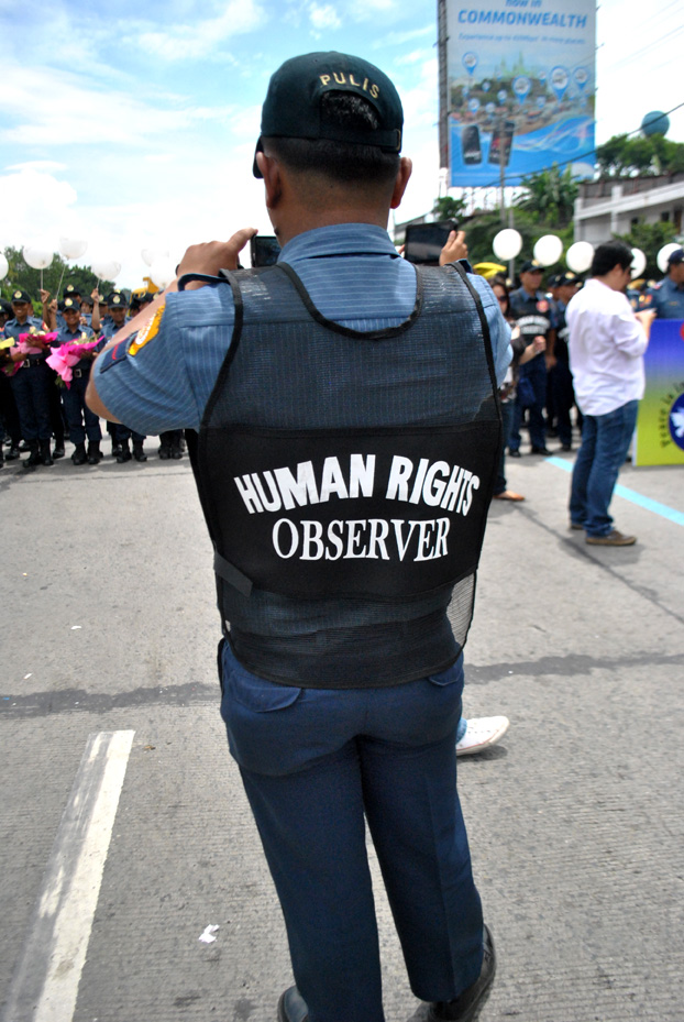 A cop who claims he is a human rights observer does some picture-taking. (Macky Macaspac)