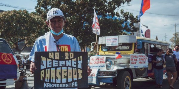 Protestor holds placard that says "no to jeepney phaseout"